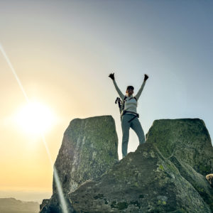 woman celebrating on Tryfan Summit near Adam and Eve rocks